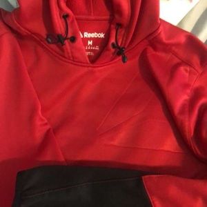 Plain red Reebok sweatshirt with black sleeves.